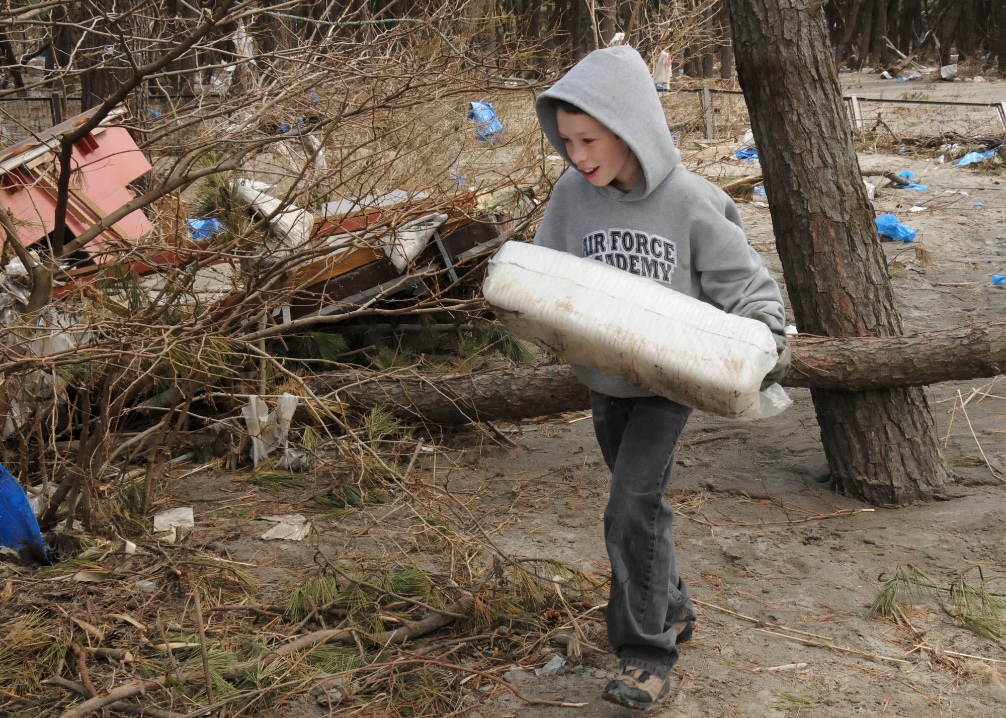 MISAWA AIR BASE, Japan -- Burke Rothstein, 10, carries a stack of Styrofoam trays to a trash pile at a park in Hachinohe, Japan, April 12. Burke, son of Col. Michael Rothstein, 35th Fighter Wing commander, volunteered with his older brother and mother. Previous Misawa Helps trip were restricted to children 16 and over.  (U.S. Air Force photo by Staff Sgt. Rachel Martinez/Released)