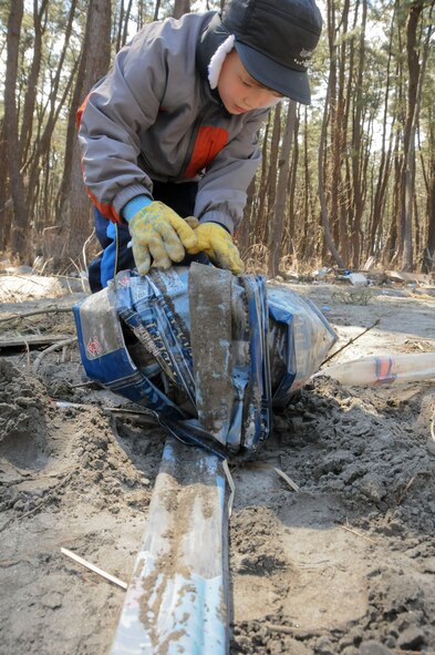 MISAWA AIR BASE, Japan -- Thomas Alley, 8, rolls up a long plastic sheet during a volunteer clean-up mission at a park in Hachinohe, Japan, April 12. Thomas, son of Capt. Merrill Alley, 35th Dental Squadron, volunteered with his mom. (U.S. Air Force photo by Staff Sgt. Rachel Martinez/Released)
