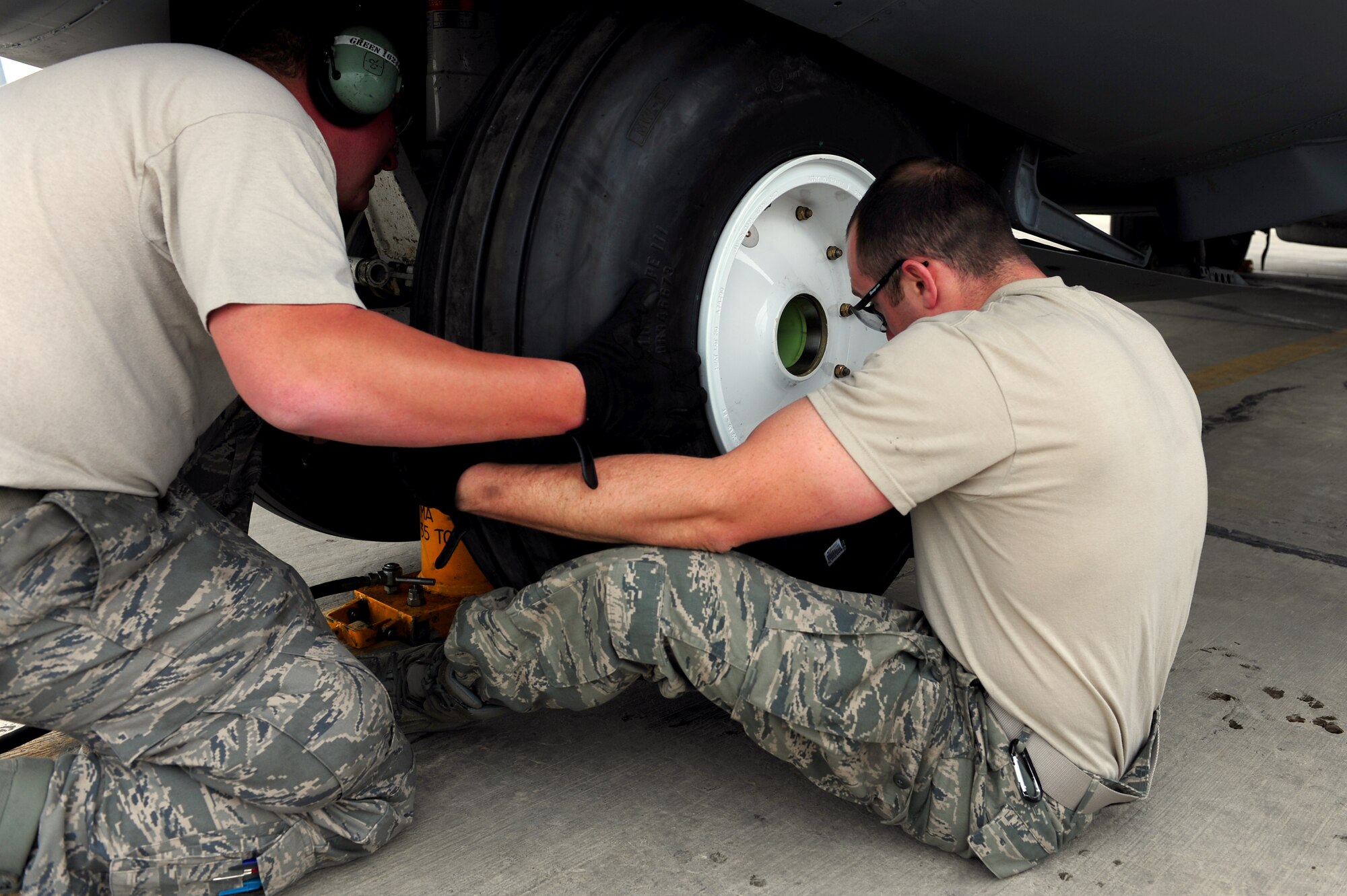 U.S. Air Force Staff Sgt. John Green and Staff Sgt. Justin Greenhow, 455th Expeditionary Aircraft Maintenance Squadron crew chiefs, position a fresh tire onto the nose landing gear of a C-130 Hercules aircraft during a tire change procedure at Bagram Airfield, Afghanistan, April 9, 2011. Green and Greenhow are deployed from the Delaware Air National Guard’s 166th Aircraft Maintenance Squadron, New Castle, Del., supporting Operation Enduring Freedom. (U.S. Air Force photo/Master Sgt. William Greer)