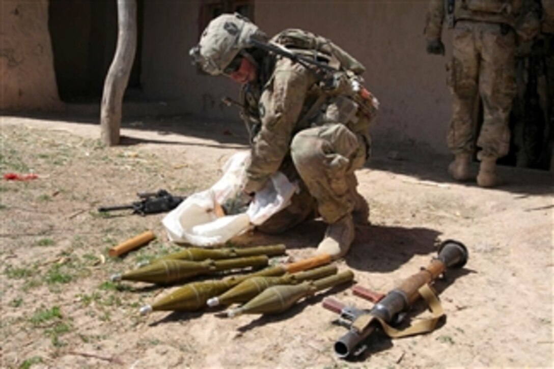 U.S. Army Sgt. Cullen Wurzer finds a bag of rocket-propelled grenades and a grenade launcher while searching a compound in Pacha Khak, Afghanistan, on April 7, 2011.  Wurzer is assigned to the 34th Infantry Division's 1st Squadron, 113th Cavalry Regiment.  