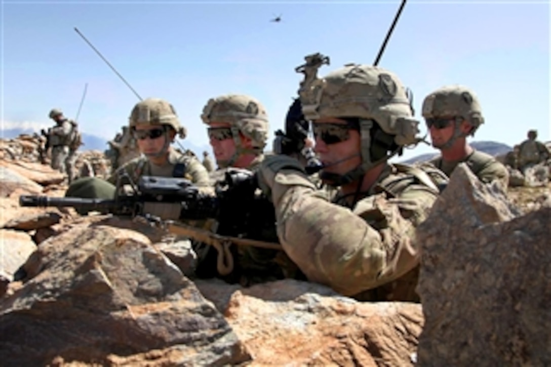 U.S. Army Sgt. Cullen Wurzer (3rd from right), Staff Sgt. Cody Johnson (4th from right), 1st Lt. Andy Zaidi (5th from right) and Spc. Shane Taylor (2nd from right) discuss plans to maneuver into Pacha Khak village, Afghanistan, while conducting a dismounted patrol on April 7, 2011.  The soldiers, assigned to 34th Infantry Division's 1st Squadron, 113th Cavalry Regiment, searched the village for weapons caches and also conducted a key leader engagement with the village malik.  