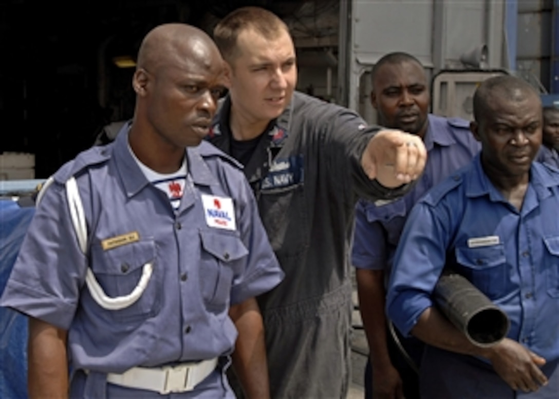 U.S. Navy Petty Officer 1st Class Eric Bel (2nd from left) instructs a member of the Nigerian Naval Police on firefighting methods during a damage control drill on the flight deck of the guided missile frigate USS Robert G. Bradley (FFG 49) in Lagos, Nigeria, as part of Africa Partnership Station West on April 11, 2011.  Africa Partnership Station is an international security cooperation initiative facilitated by Commander, U.S. Naval Forces Europe-Africa aimed at strengthening global maritime partnerships through training and collaborative activities in order to improve maritime safety and security in Africa.  