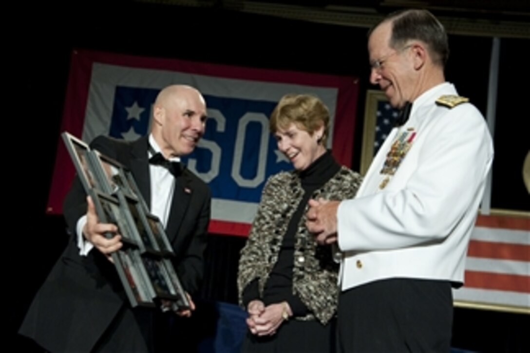 USO Chairman of the Board of Directors John Marselle presents Chairman of the Joint Chiefs of Staff Adm. Mike Mullen and his wife Deborah with a gift at the 2011 USO Metro Awards Dinner at the Ritz-Carlton Hotel in Pentagon City, Va., on April 12, 2011.  