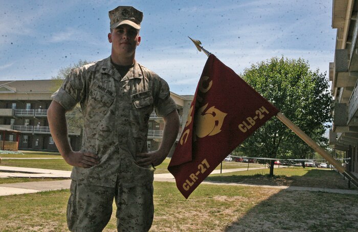 Cpl. Aric M. Mauldin, an administration specialist with Combat Logistics Battalion 24, Combat Logistics Regiment 27, 2nd Marine Logistics Group, poses for a photo next to their battalion guidon aboard Camp Lejeune, N.C. April 14, 2011.  Mauldin was selected as the Marine of the Quarter for the regiment out of five other Marines nominated. (U.S. Marine Corps photo by Cpl. Melissa A. Latty)