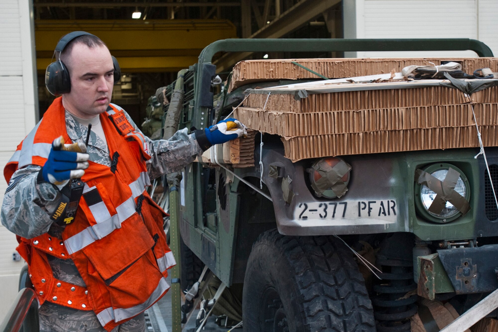 JOINT BASE ELMENDORF-RICHARDSON, Alaska -Tech. Sgt. Nathan Austin, 732nd Air Mobility Squadron, signals to one of his Airman to move the 32-foot platform, consisting of a humvee and howitzer, forward. Members of the 732nd AMS were preparing to move the platform onto the back of a C-130 April 4.   The C-130 J Model was from the 19th Airlift Wing, Little Rock Air Force Base, Arkansas. This was in preparation for a heavy drop and personnel drop performed with the 3rd Battalion, 377th Parachute Field Artillery Regiment. (U.S. Air Force photo/Senior Airman Christopher Gross)  