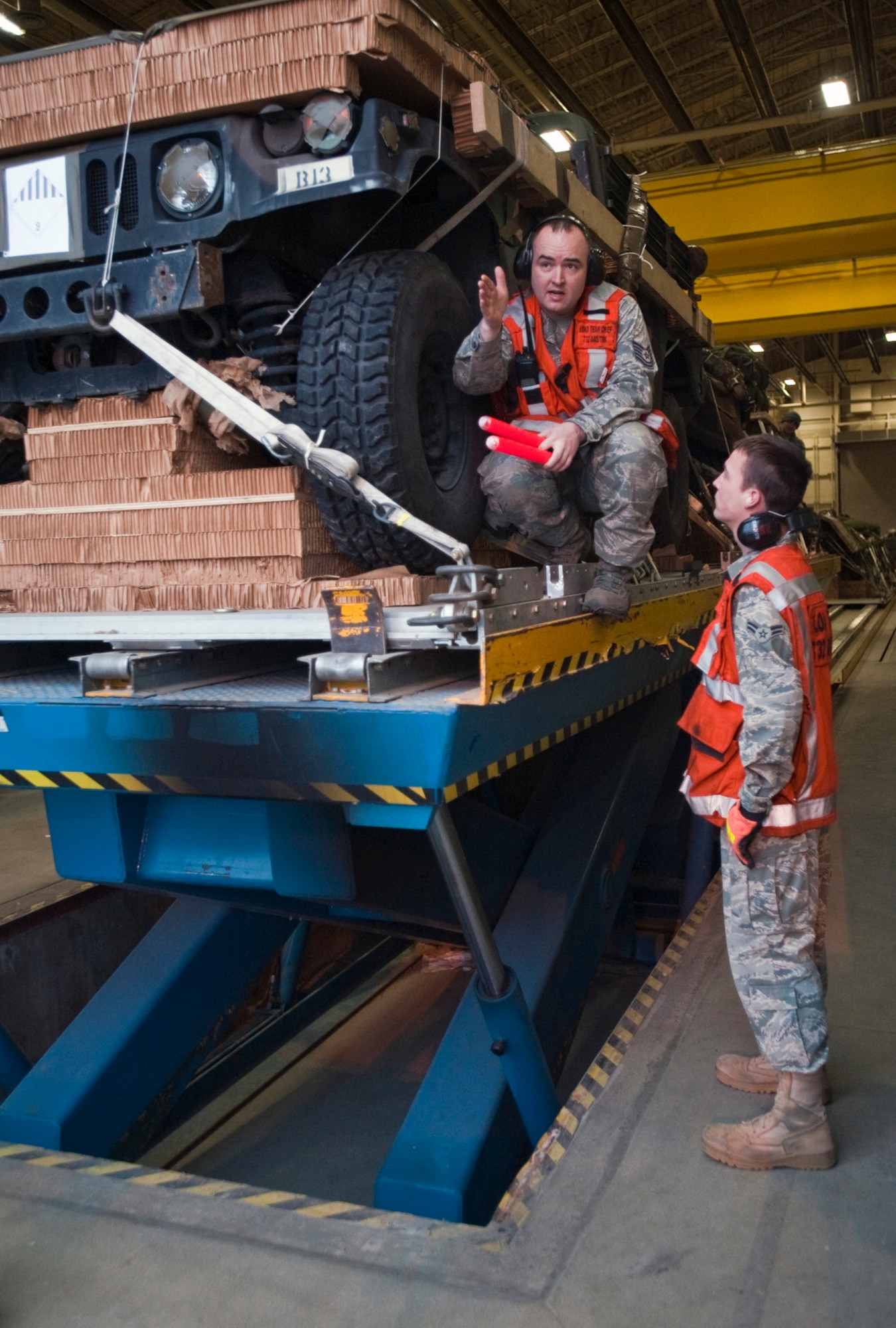 JOINT BASE ELMENDORF-RICHARDSON, Alaska - Tech. Sgt. Nathan Austin gives instructions to Airman 1st Class David Clontz, both of the 732nd Air Mobility Squadron, while they prepare to load a 32-foot platform consisting of a humvee and howitzer into the back of a C-130 April 4.   The C-130 J Model was from the 19th Airlift Wing, Little Rock Air Force Base, Arkansas. This was in preparation for a heavy drop and personnel drop performed with the 3rd Battalion, 377th Parachute Field Artillery Regiment. (U.S. Air Force photo/Senior Airman Christopher Gross)  