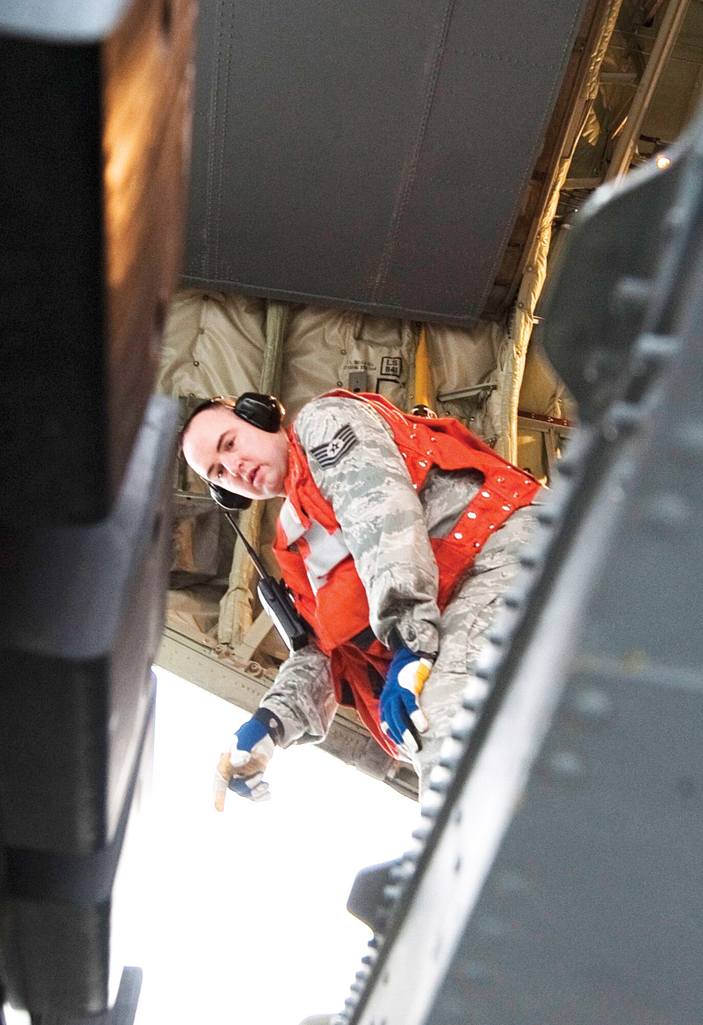 JOINT BASE ELMENDORF-RICHARDSON, Alaska - Tech. Sgt. Nathan Austin, 732nd Air Mobility Squadron, checks the space between the aircraft and truck as members of the 732nd AMS loaded a 32-foot platform, consisting of a humvee and howitzer, into the back of a C-130J Hercules, April 4.  (U.S. Air Force photo/Senior Airman Christopher Gross)  