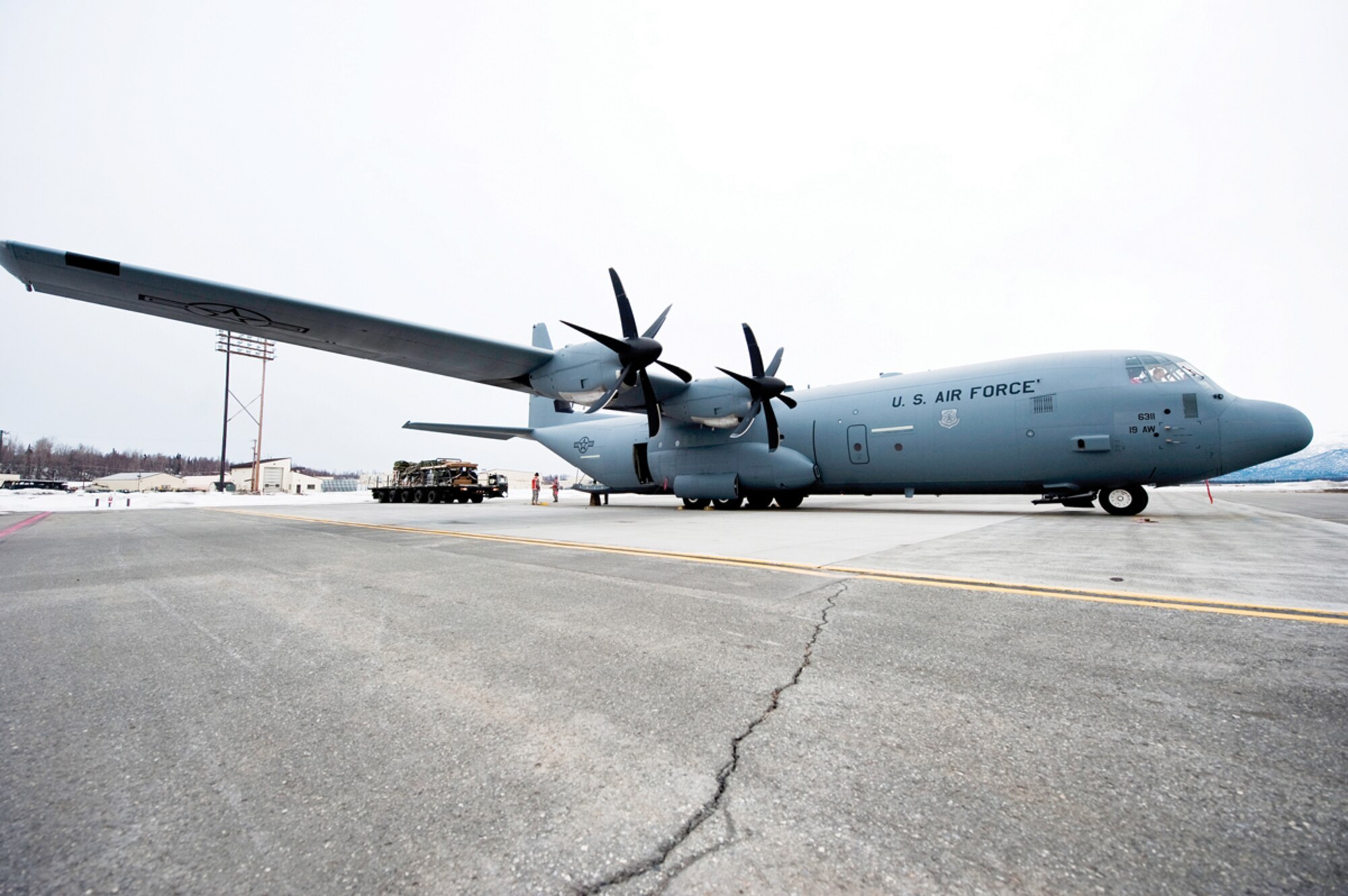 JOINT BASE ELMENDORF-RICHARDSON, Alaska - A C-130J model Hercules from the 19th Airlift Wing, Little Rock Air Force Base, Ark., sits on the Joint Base Elmendorf-Richardson flight line, April 4, while members of the 732nd Air Mobility Squadron load a 32-foot platform consisting of a Humvee and howitzer onto the cargo floor. This was in preparation for a heavy drop and personnel drop performed with the 3rd Battalion, 377th Parachute Field Artillery Regiment. The exercise marked the first time Soldiers of 4th Brigade Combat Team (Airborne), 25th Infantry Division worked with the Air Force's newest C-130 variant. (U.S. Air Force photo/Senior Airman Christopher Gross)  
