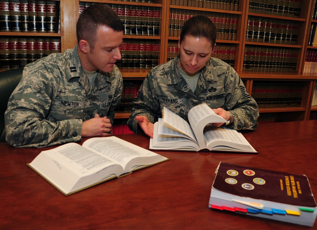 (Left to right) Capt. Christopher Newton, 28th Bomb Wing Judge Advocate officer in-charge of operational law, and Master Sgt. Kathy Evans, 28th BW JA law office superintendent, review legal books from the law office library at Ellsworth Air Force Base, S.D., April 14, 2011.  The legal office works with Airmen on a wide variety of legal issues ranging from powers of attorney to disciplinary actions. (U.S. Air Force photo/Senior Airman Anthony Sanchelli)
