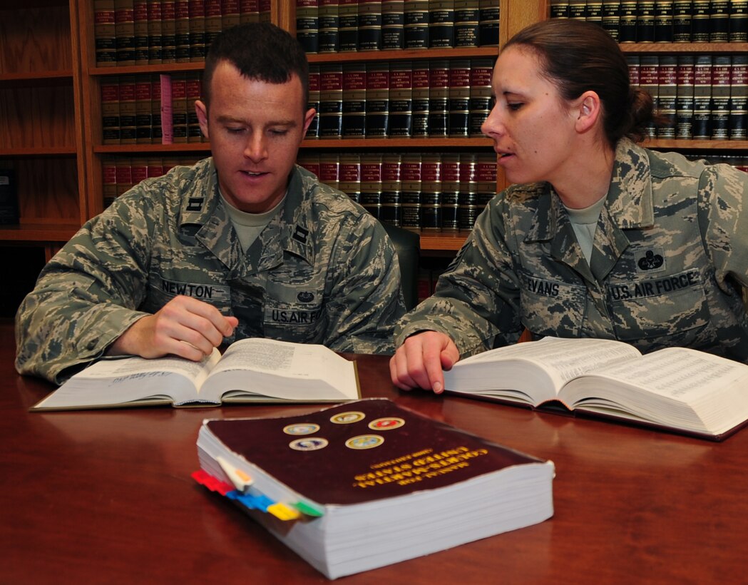 (Left to right) Capt. Christopher Newton, 28th Bomb Wing Judge Advocate officer in-charge of operational law, and Master Sgt. Kathy Evans, 28th BW JA law office superintendent, review legal books from the law office library at Ellsworth Air Force Base, S.D., April 14, 2011.  The legal office works with Airmen on a wide variety of legal issues ranging from powers of attorney to disciplinary actions. (U.S. Air Force photo/Senior Airman Anthony Sanchelli)
