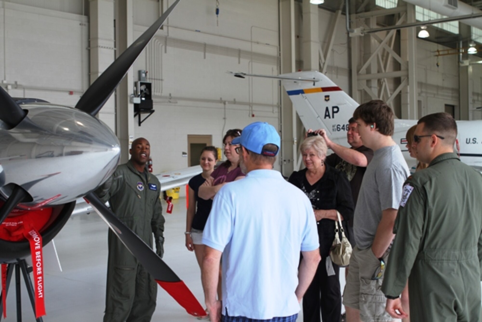 NAVAL AIR STATION PENSACOLA, Fla. -- Capt. Julian Venton, 479th Flying Training Group T-6 Texan II instructor pilot, explains the features and capabilities of a T-6 to family members of students in the Combat Systems Officer Course April 14. The tour was a part of the Red Carpet Day prior to the graduation of the first class to undergo combat systems officer training. The graduation will take place April 15. (U.S. Air Force photo/2nd Lt. Charles J. Hopkins IV)