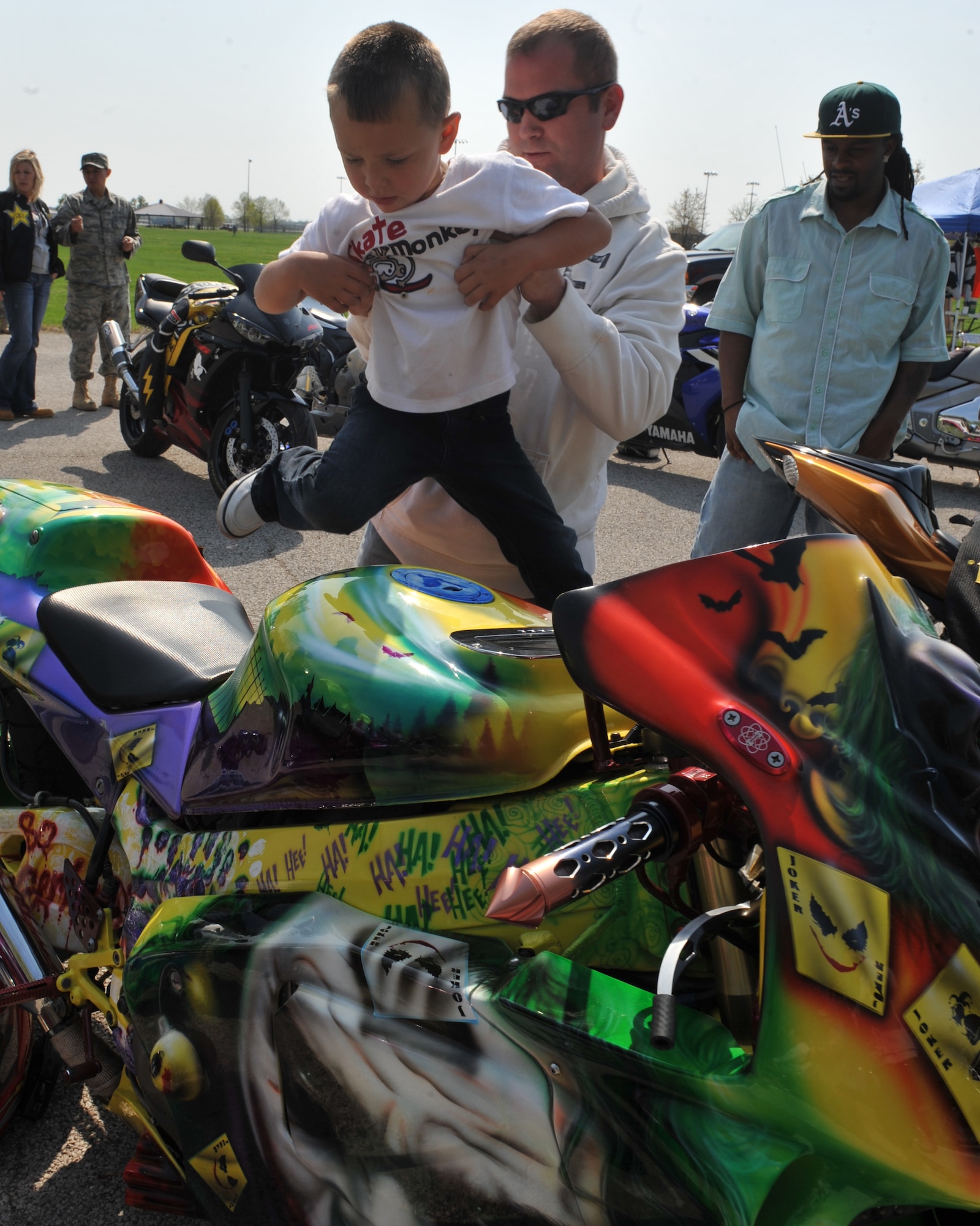 Tech. Sgt. David Eads, 375th Medical Support Squadron medical administrator, helps Hunter Neese, four years old, on his motorcycle "The Joker" during the motorcycle safety day at Scott Air Force Base, Ill., April 14, 2011. The Motorcycle Safety Day brought members of Scott together to talk to venders and to watch the Illinois State Troopers perform on their motorcycles. (U.S. Air Force photo/Senior Airman Tristin English)