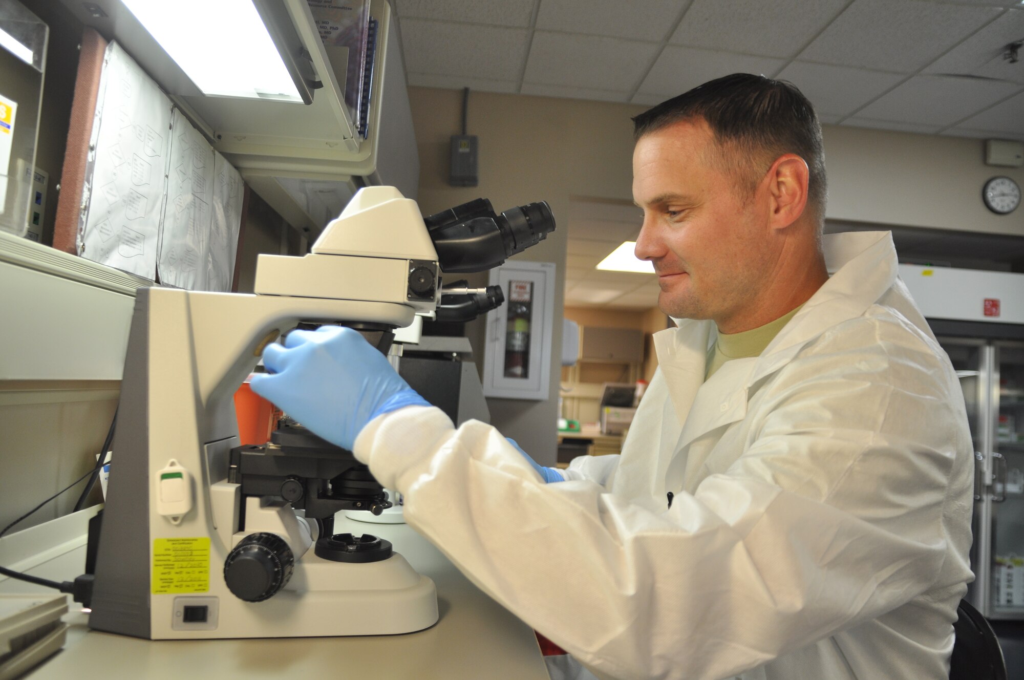 Tech. Sgt. Brian Fisher, 14th Medical Support Squadron labratory NCOIC, switches the his microscope's lense while studying a sample.