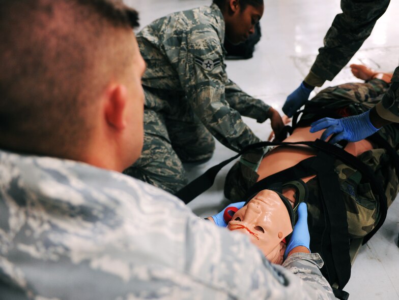 MOODY AIR FORCE BASE, Ga.-- Staff Sgt. Dennis Seymour, 820th Combat Operations Squadron training NCO, holds the neck of a simulated trauma victim as other students straps the victim to a spine board during the first responder’s course April 13. Students participated in the three day course to become first responder’s for their respective units. (U.S. Air Force photo/Airman 1st Class Benjamin Wiseman)(RELEASED)