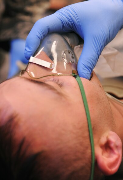 MOODY AIR FORCE BASE, Ga.-- An oxygen mask is administered to Airman 1st Class Jarrett Rowe, 824th Base Defense Squadron member and practical exam volunteer, during the bleed control and shock treatment portion of the first responders course April 13. The course was three days long and the students were tested on the third day with a written exam and a practical application demonstration. (U.S. Air Force photo/Airman 1st Class Benjamin Wiseman)(RELEASED)