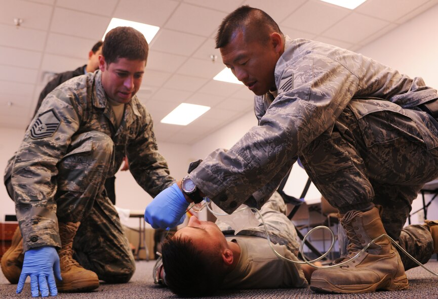 MOODY AIR FORCE BASE, Ga.--Master Sgts. Samuel Louie and Jason Castro, 820th Combat Operations Squadron, treat Airman 1st Class Jarrett Rowe, 824th Base Defense Squadron member and practical exam volunteer, during the bleeding control and shock treatment portion of the first responders course April 13. The first responder’s course gives personnel the ability to assess and treat accident victims until higher qualified medical providers arrive on scene. (U.S. Air Force photo/Airman 1st Class Benjamin Wiseman)(RELEASED)