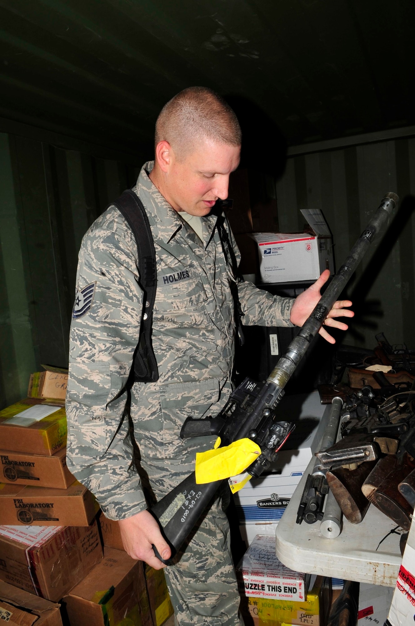 U.S. Air Force Tech. Sgt. Aaron Holmes, Law and Order Task Force paralegal, deployed from Grand Forks Air Force Base, N.D., and native of Cabot, Ark., conducts an inventory of weapons held as evidence at Joint Security Station Shield, Iraq, April 7, 2011. The Cabot, Ark., native safeguards these items to help ensure a fair and impartial trial under Iraq law for detainees accused of criminal and terrorist activity. (U.S. Air Force photo by Senior Master Sgt. Larry A. Schneck/Released)