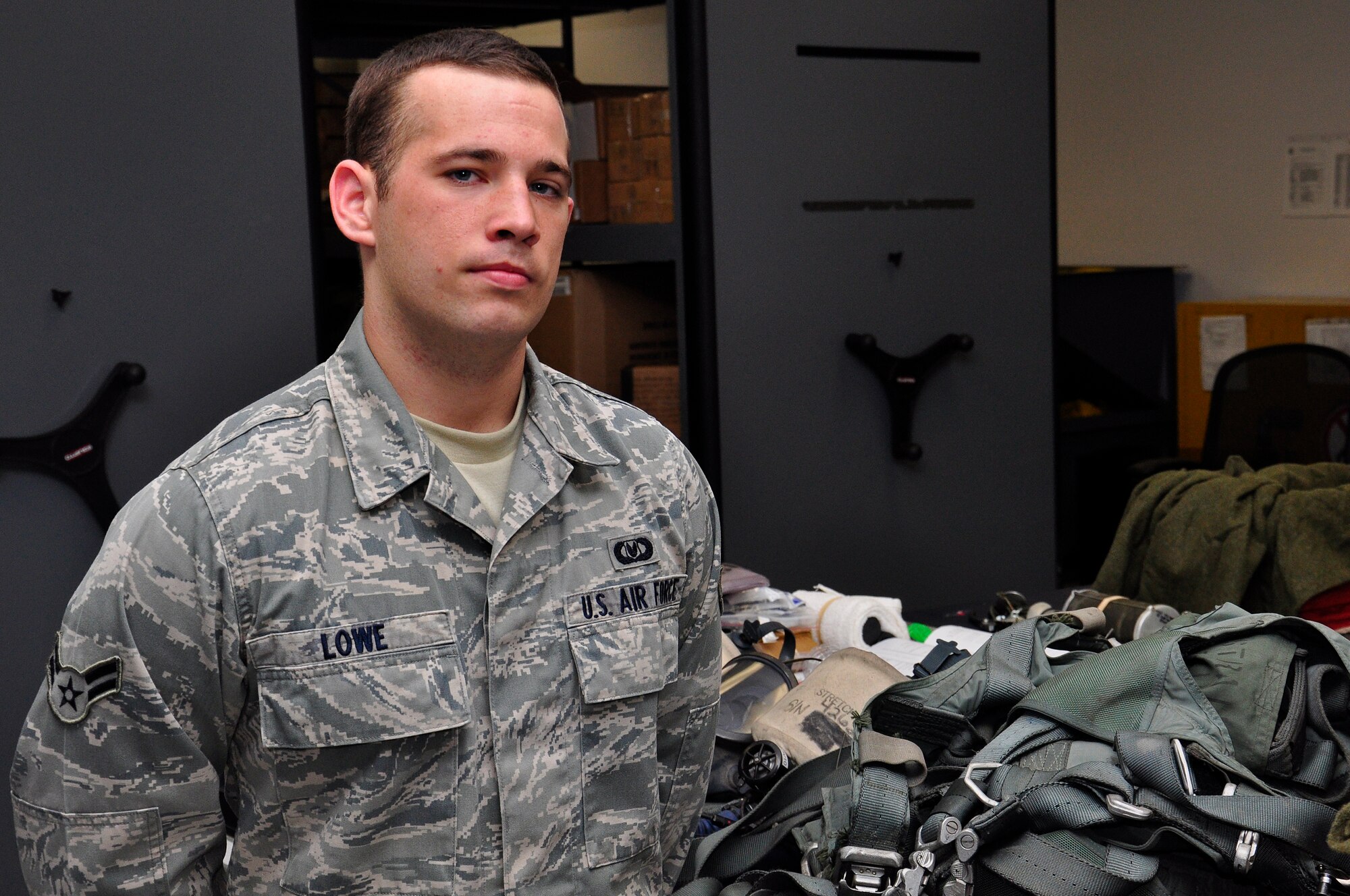 Airman 1st Class Russell Lowe, 9th Special Operations Squadron aircrew flight equipment journeyman, was selected for this week's Tip of the Spear spotlight at Eglin Air Force Base, Fla., April 13, 2011. The 9th SOS is a tenant unit of the 1st Special Operations Wing stationed at Eglin AFB. Airman Lowe stands beside safety equipment being prepared for use. (U.S. Air Force photo by Staff Sgt. William Banton / RELEASED)