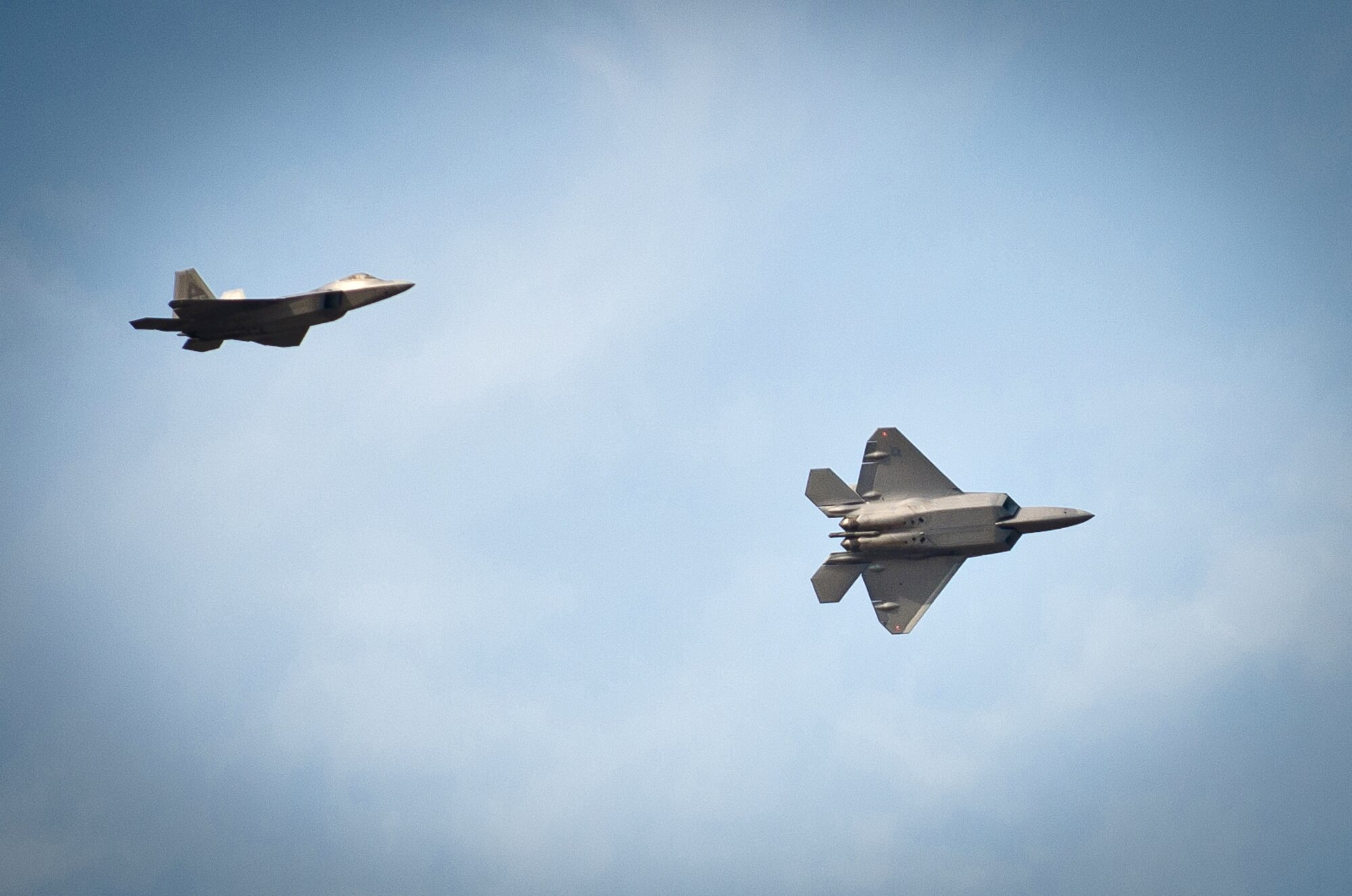 Two U.S. Air Force F-22s from the Raptor Demonstration Team practice an aerobatic maneuver as they fly over the Kentucky Air National Guard Base in Louisville, Ky., on April 14, 2011. The F-22s, based at Langley Air Force Base, Va., will be one of the marquee attractions of this year?s Thunder Over Louisville air show, scheduled to take place over the Ohio River in downtown Louisville on April 16. (U.S. Air Force photo by Maj. Dale Greer)