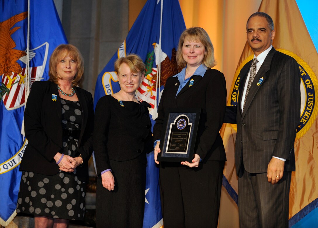 Dr. Charlotte Moerbe (second from right), the Joint Base San Antonio sexual assault response coordinator, receives a Federal Service Award during the National Crime Victims' Service Awards ceremony April 8, 2011, in Washington, D.C.  Dr. Moerbe was recognized for her work supporting military members recovering from sexual violence. She is joined by (from left) Joye E. Frost, acting director of the Office for Victims of Crime; Laurie O. Robinson, Assistant Attorney General, Office of Justice Programs; and Attorney General Eric Holder. (U.S. Air Force photo/Scott M. Ash)