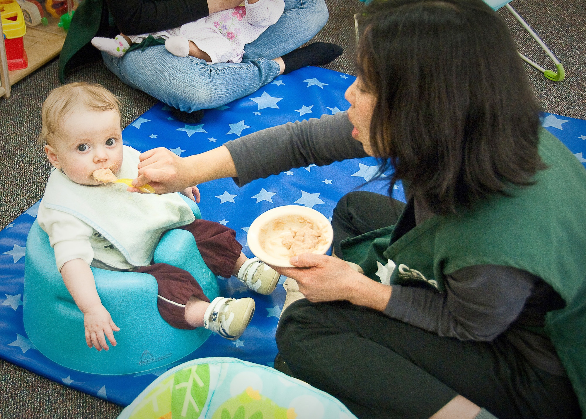 Yukie Kuramochi, a caregiver at the Yume Child Development Center at Yokota Air Base, Japan, feeds a child April 12, 2011. Caregivers at Yokota Air Base CDCs work together to continue normal routines with the children by carrying on everyday activities in the aftermath of the earthquake and tsunami. (U.S. Air Force photo/Airman 1st Class Lynsie Nichols) 