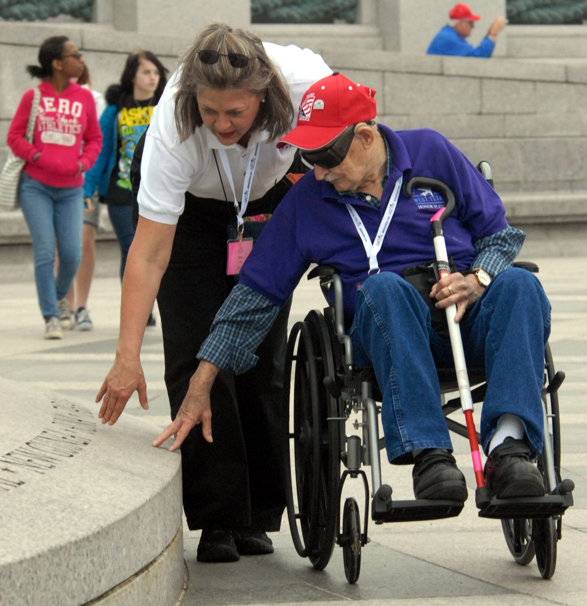 DYESS AIR FORCE BASE, Texas - An Abilene, Texas volunteer talks with one of more than 200 World War II veterans while visiting the World War II Memorial in Washington D.C. April 12 as part of a West Texas Honor Flight Network event. The Honor Flight Network is a non-profit organization created to honor America’s veterans for their sacrifices by transporting these heroes to Washington D.C. to visit and reflect at their memorials at no cost to themselves. Honor Flight trips are made possible through donations; discounts by charter bus companies, airlines, hotels and more; and through volunteers, of which more than 100 were present during this West Texas Honor Flight. (Air Force photo/Tech. Sgt. Robert Wollenberg)