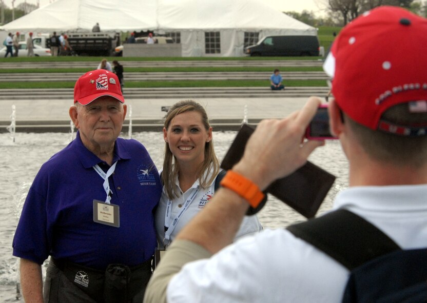 DYESS AIR FORCE BASE, Texas - A Dyess Air Force Base Airman takes a picture of one of more than 200 World War II veterans posing with Senior Airman Jamie Smith, 7th Operations Support Squadron, while visiting the World War II Memorial in Washington D.C. April 12 as part of a West Texas Honor Flight Network event. The Honor Flight Network is a non-profit organization created to honor America’s veterans for their sacrifices by transporting these heroes to Washington D.C. to visit and reflect at their memorials at no cost to themselves. Honor Flight trips are made possible through donations; discounts by charter bus companies, airlines, hotels and more; and through volunteers, of which more than 100 were present during this West Texas Honor Flight. (Air Force photo/Tech. Sgt. Robert Wollenberg)