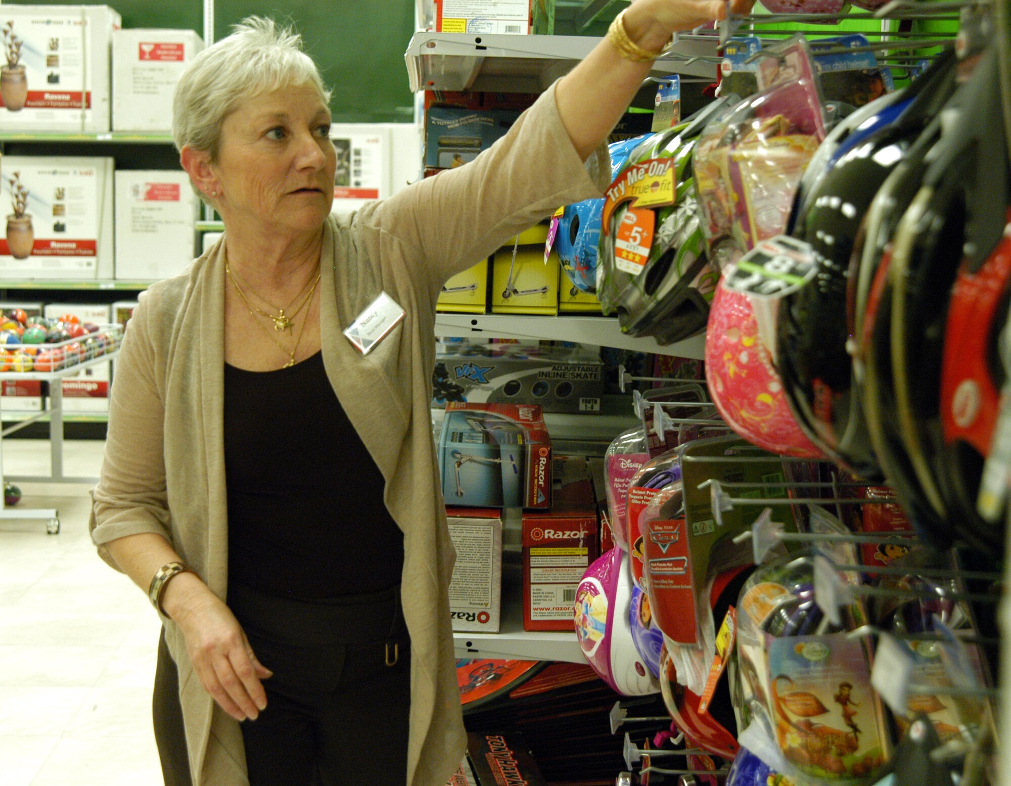OFFUTT AIR FORCE BASE, Neb. -- Nancy Copada, Offutt Exchange main store manager, adjusts some bike helmets on display in the toy section of the Base Exchange here March 16. Ms. Copada has worked for the Army and Air Force Exchange Service for 26 years and said she loves working for the company. In 2005 she served a seven-month deployment in Iraq supporting U.S. servicemembers. U.S. Air Force photo by Staff Sgt. James M. Hodgman (Released)