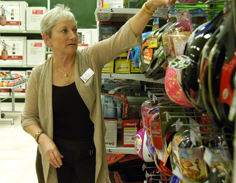 OFFUTT AIR FORCE BASE, Neb. -- Nancy Copada, Offutt Exchange main store manager, adjusts some bike helmets on display in the toy section of the Base Exchange here March 16. Ms. Copada has worked for the Army and Air Force Exchange Service for 26 years and said she loves working for the company. In 2005 she served a seven-month deployment in Iraq supporting U.S. servicemembers. U.S. Air Force photo by Staff Sgt. James M. Hodgman (Released)