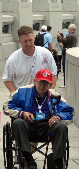 DYESS AIR FORCE BASE, Texas - Maj. Brian Wallace, 7th Bomb Wing, helps one of more than 200 World War II veterans around the World War II Memorial in Washington D.C. April 12 as part of a West Texas Honor Flight Network event. The Honor Flight Network is a non-profit organization created to honor America’s veterans for their sacrifices by transporting these heroes to Washington D.C. to visit and reflect at their memorials at no cost to themselves. Honor Flight trips are made possible through donations; discounts by charter bus companies, airlines, hotels and more; and through volunteers, of which more than 100 were present during this West Texas Honor Flight. (Air Force photo/Tech. Sgt. Robert Wollenberg)
