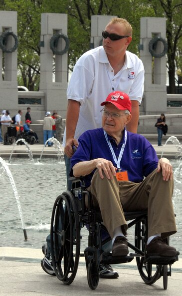 DYESS AIR FORCE BASE, Texas - A Dyess Airman helps one of more than 200 World War II veterans around the World War II Memorial in Washington D.C. April 12 as part of a West Texas Honor Flight Network event. The Honor Flight Network is a non-profit organization created to honor America’s veterans for their sacrifices by transporting these heroes to Washington D.C. to visit and reflect at their memorials at no cost to themselves. Honor Flight trips are made possible through donations; discounts by charter bus companies, airlines, hotels and more; and through volunteers, of which more than 100 were present during this West Texas Honor Flight. (Air Force photo/Tech. Sgt. Robert Wollenberg)