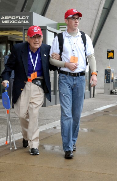 DYESS AIR FORCE BASE, Texas - Senior Airman Ryan Fowler, 77th Weapons Squadron, helps one of more than 200 World War II veterans through the Dulles International Airport in Chantilly, Va. April 12 as part of a West Texas Honor Flight Network event. The Honor Flight Network is a non-profit organization created to honor America’s veterans for their sacrifices by transporting these heroes to Washington D.C. to visit and reflect at their memorials at no cost to themselves. Honor Flight trips are made possible through donations; discounts by charter bus companies, airlines, hotels and more; and through volunteers, of which more than 100 were present during this West Texas Honor Flight. (Air Force photo/Tech. Sgt. Robert Wollenberg)