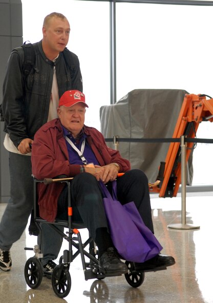 DYESS AIR FORCE BASE, Texas - A Dyess Air Force Base Airman helps one of more than 200 World War II veterans through the Dulles International Airport in Chantilly, Va. April 12 as part of a West Texas Honor Flight Network event. The Honor Flight Network is a non-profit organization created to honor America’s veterans for their sacrifices by transporting these heroes to Washington D.C. to visit and reflect at their memorials at no cost to themselves. Honor Flight trips are made possible through donations; discounts by charter bus companies, airlines, hotels and more; and through volunteers, of which more than 100 were present during this West Texas Honor Flight. (Air Force photo/Tech. Sgt. Robert Wollenberg)