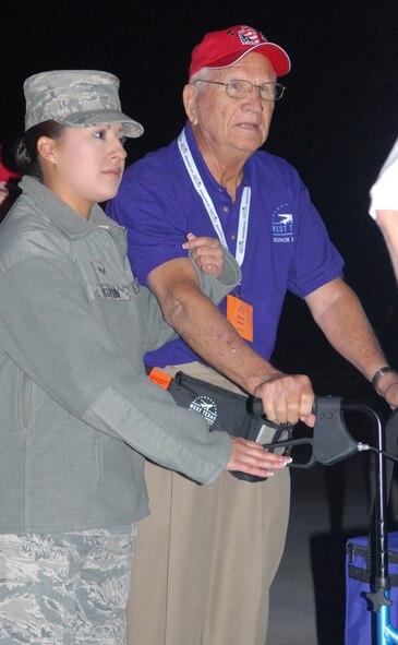 DYESS AIR FORCE BASE, Texas - Airman 1st Class Ashley Nguyen, 7th Communication Squadron, helps one of more than 200 World War II veterans board a plane April 12 at the Abilene Regional Airport bound for Washington D.C. as part of a West Texas Honor Flight Network event. The Honor Flight Network is a non-profit organization created to honor America’s veterans for their sacrifices by transporting these heroes to Washington D.C. to visit and reflect at their memorials at no cost to themselves. Honor Flight trips are made possible through donations; discounts by charter bus companies, airlines, hotels and more; and through volunteers, of which more than 100 were present during this West Texas Honor Flight. (Air Force photo/Tech. Sgt. Robert Wollenberg)
