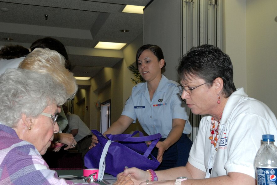 DYESS AIR FORCE BASE, Texas - Airman 1st Class Vanessa Baldovino, 7th Component Maintenance Squadron, helps World War II veterans inprocess for “their trip of a lifetime” April 11 at the MGM Elegante hotel as part of a West Texas Honor Flight Network event to Washington D.C. The Honor Flight Network is a non-profit organization created to honor America’s veterans for their sacrifices by transporting these heroes to Washington D.C. to visit and reflect at their memorials at no cost to themselves. Honor Flight trips are made possible through donations; discounts by charter bus companies, airlines, hotels and more; and through volunteers, of which more than 100 were present during this West Texas Honor Flight. (Air Force photo/Tech. Sgt. Robert Wollenberg)