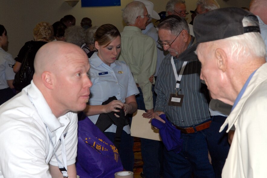 DYESS AIR FORCE BASE, Texas - Senior Airman Jamie Smith, 7th Operations Support Squadron, helps World War II veterans inprocess for their “trip of a lifetime” April 11 at the MGM Elegante hotel as part of a West Texas Honor Flight Network event to Washington D.C. The Honor Flight Network is a non-profit organization created to honor America’s veterans for their sacrifices by transporting these heroes to Washington D.C. to visit and reflect at their memorials at no cost to themselves. Honor Flight trips are made possible through donations; discounts by charter bus companies, airlines, hotels and more; and through volunteers, of which more than 100 were present during this West Texas Honor Flight. (Air Force photo/Tech. Sgt. Robert Wollenberg)