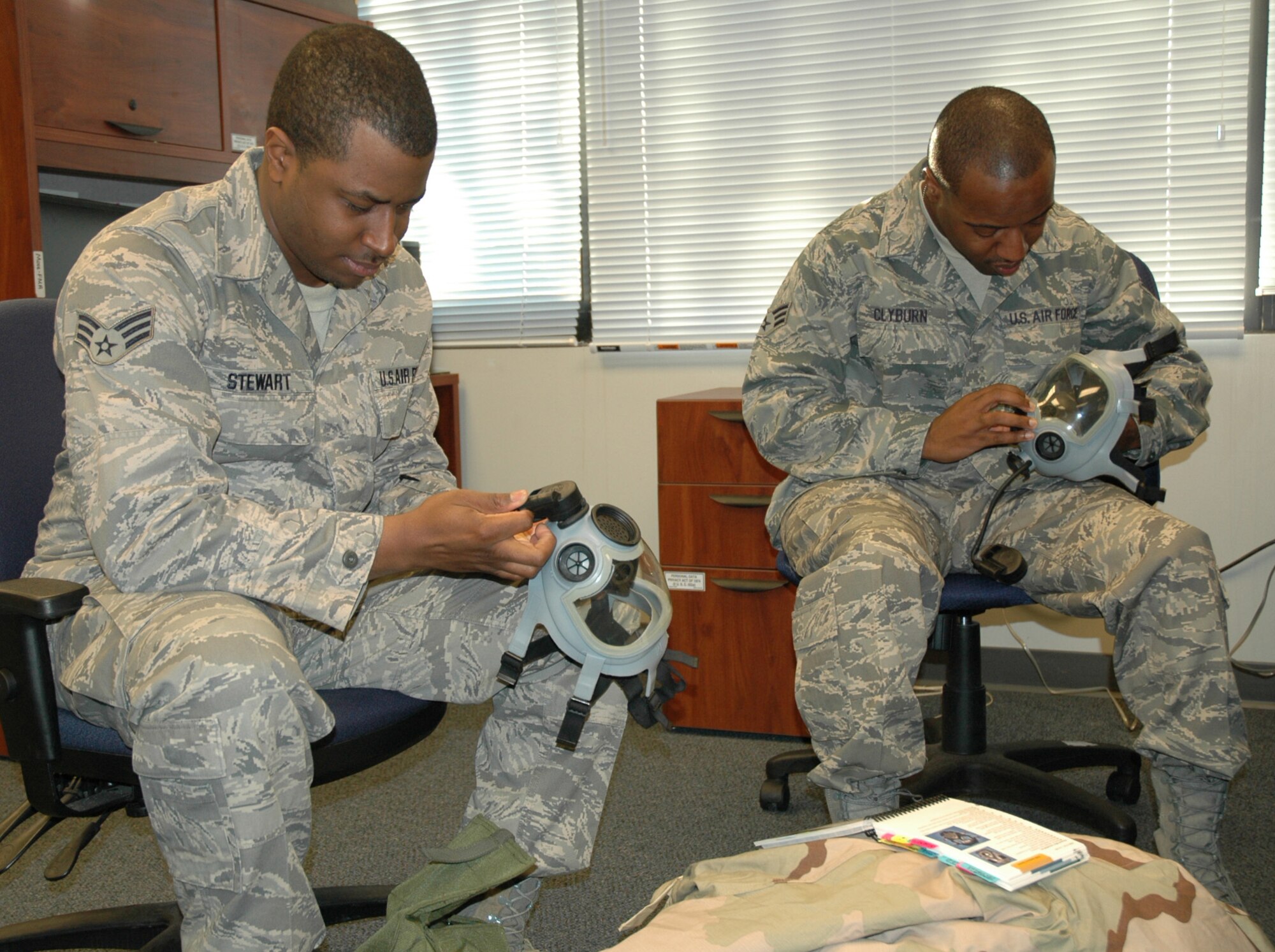 Senior Airman Sean Stewart and now Staff Sgt. Ceasal Clyburn inspect their gas masks during the February Unit Training Assembly. Both reservists work in the 512th Airlift Wing Financial Management Office, which Air Force Reserve Command selected as the Financial Management and Comptroller Organization of the Year for 2010. (U.S. Air Force photo by Staff Sgt. Danella Shea)