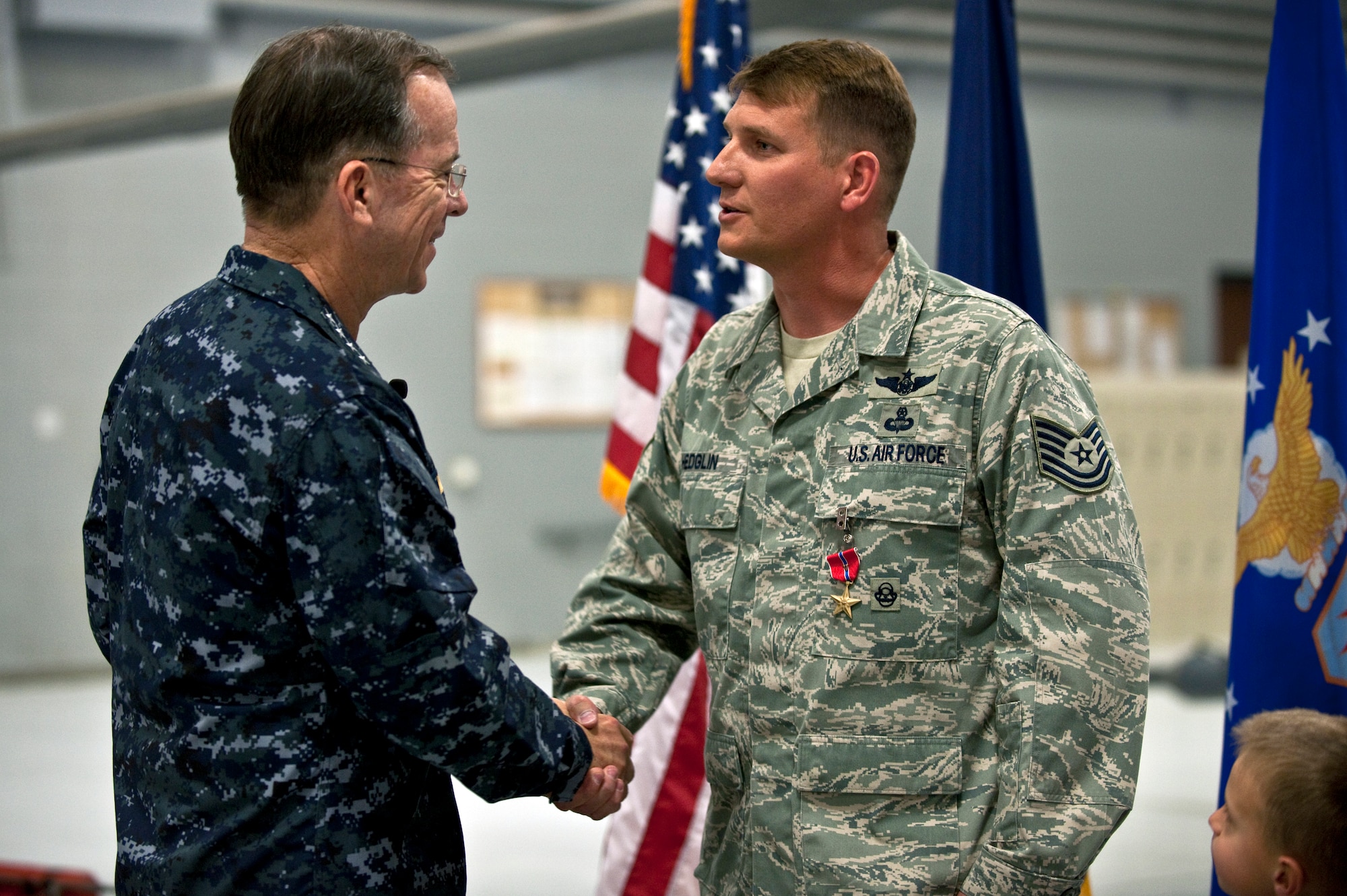 NELLIS AIR FORCE BASE, Nev. -- Chairman of the Joint Chiefs of Staff Navy Adm. Mike Mullen congratulates  Tech. Sgt. Jeffrey Hedglin after awarding him a Bronze Star with valor April 13. Sergeant Hedglin is one of three pararescuemen awarded the Bronze Star for their heroic actions while rescuing American Soldiers last year in Afghanistan. (U.S. Air Force photo by Tech. Sgt. Michael Holzworth)