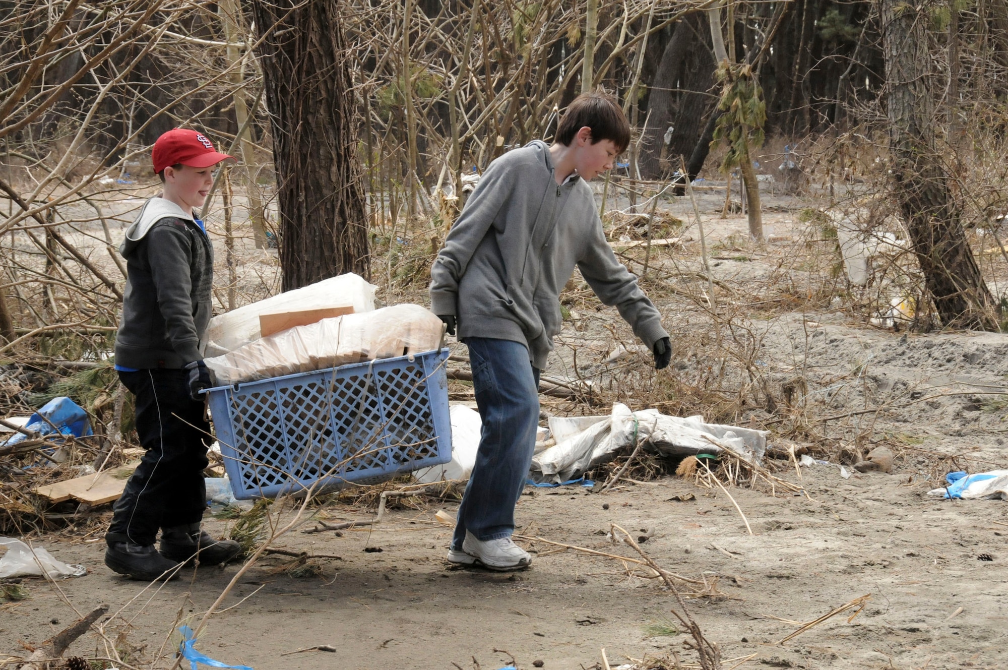 Garrett Whitaker, 8, and Seth Rothstein, 12, carry a pile of trash out of the woods at a park April 12, 2011, in Hachinohe, Japan. Garrett is the son of Maj. Greg Whitaker, the 35th Communications Squadron commander. Seth is the son of Col. Michael Rothstein, the 35th Fighter Wing commander. (U.S. Air Force photo/Staff Sgt. Rachel Martinez)