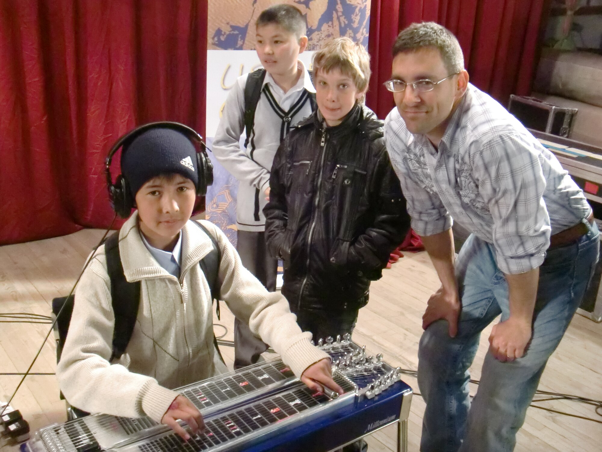 Technical Sgt. Jeff Valentine show some students "the sound of country music"....the Steel Guitar, after AFCENT Band Wild Blue Country's performance at the Kant House of Culture. (U.S. Air Force photo by Master Sgt. Karl Bradley)