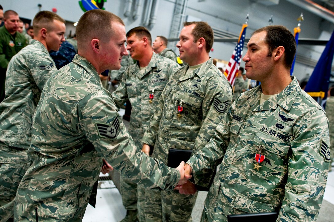 Airmen congratulate Air Force Tech Sgts. Jeffery Hedglin and Ryan Manjuck and Staff Sgt. Asher Woodhouse after they received the Bronze Star on Nellis Air Force Base, Nev., April 13, 2011.