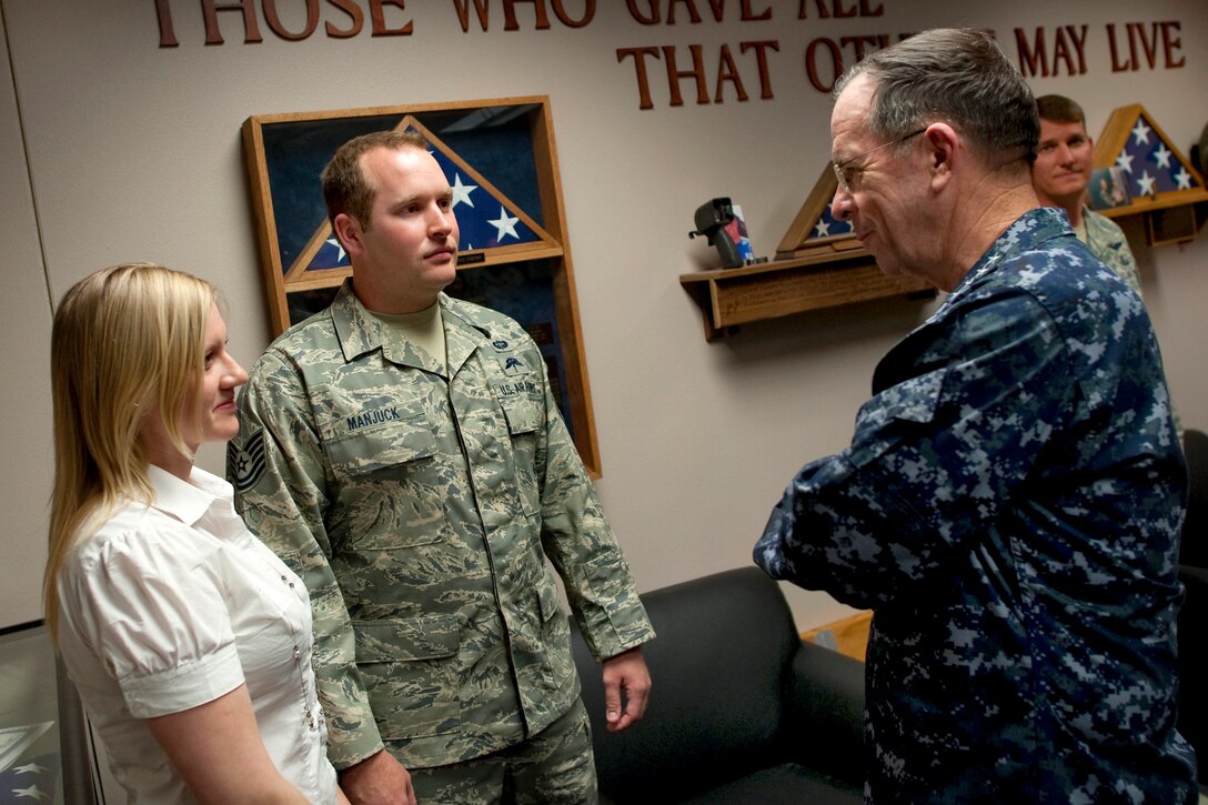 Navy Adm. Mike Mullen, chairman of the Joint Chiefs of Staff, right, visits with Air Force Tech Sgt. Ryan Manjucj, and his wife, Sarah, during a visit to Nellis Air Force Base, Nev., April 13, 2011. Manjuck and three fellow pararescuemen assigned to the 58th Rescue Squadron received the Bronze Star for heroism in Afghanistan.