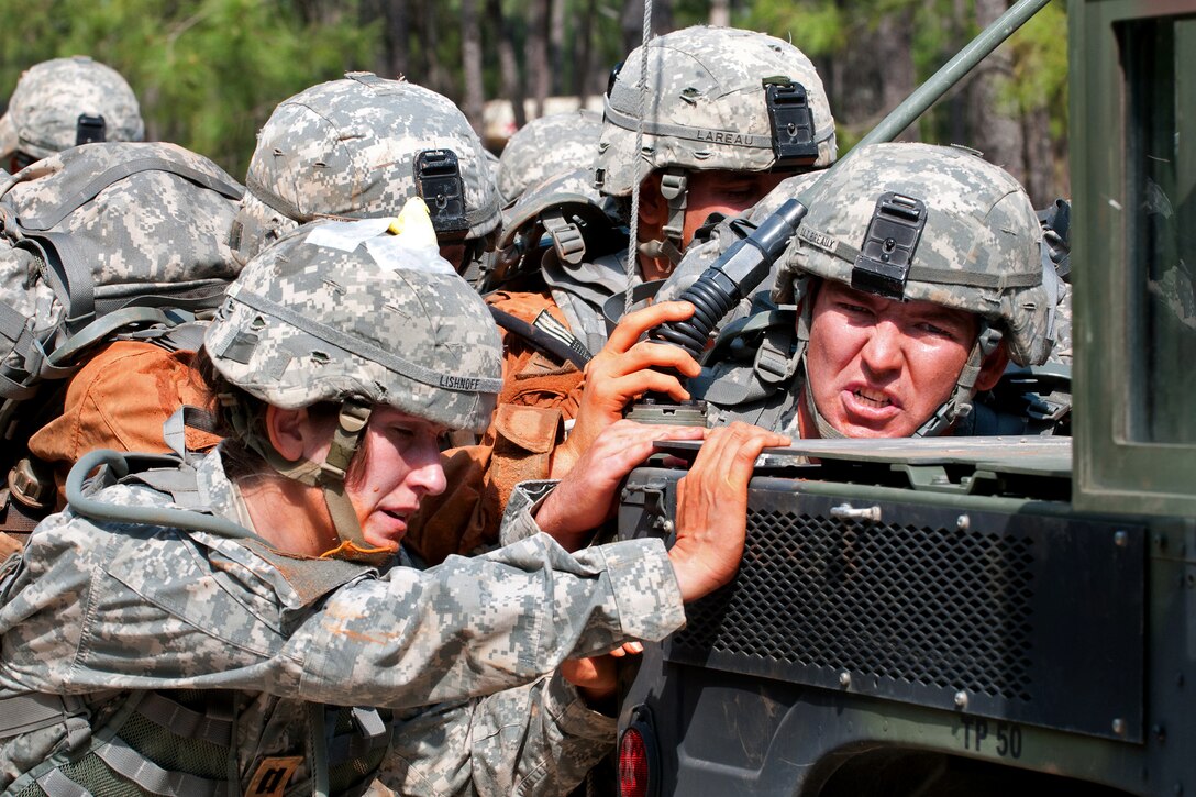 U.S. Army Capts. Dawn Lishnoff, Christopher Lareau and 1st Lt. Ryan Breaux push an up-armored Humvee during a team-building exercise that is part of Prop Blast, a traditional event that welcomes new officers to the division on Fort Bragg, N.C., April 8, 2011. Lishnoff, Lareau and Breaux are assigned to the 82nd Airborne Division’s 1st Brigade Combat Team.