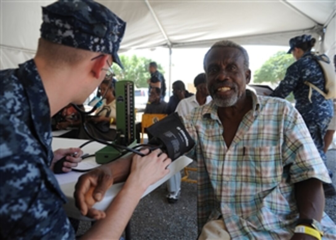U.S. Navy Petty Officer Ryan Wyatt (left) examines a patient on the first day of a medical screening clinic in Kingston, Jamaica, during Continuing Promise 2011 on April 13, 2011.  Continuing Promise is a five-month humanitarian assistance mission in the Caribbean and Central and South America.  
