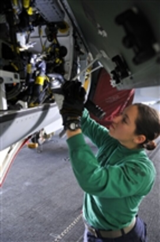 U.S. Navy Petty Officer 2nd Class Adrian Ostolski sprays corrosion preventive compound into the avionics bay of an F/A-18F Super Hornet aircraft assigned to Strike Fighter Squadron 154 while performing scheduled maintenance aboard the aircraft carrier USS Ronald Reagan (CVN 76) in the Pacific Ocean on April 6, 2011.  
