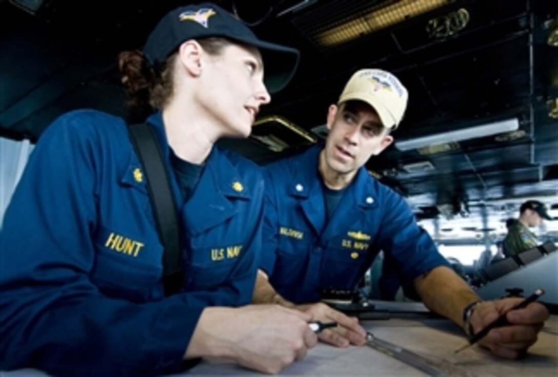 Cmdr. Christopher Valdivia, auxiliaries officer aboard the aircraft carrier USS Carl Vinson (CVN 70), explains how to plot the ship's coordinates to training officer Lt. Cmdr. Amy Hunt on the ship's bridge underway in the Arabian Sea on April 12, 2011.  The Carl Vinson and Carrier Air Wing 17 are conducting maritime security operations and air support missions in the U.S. 5th Fleet area of responsibility.  