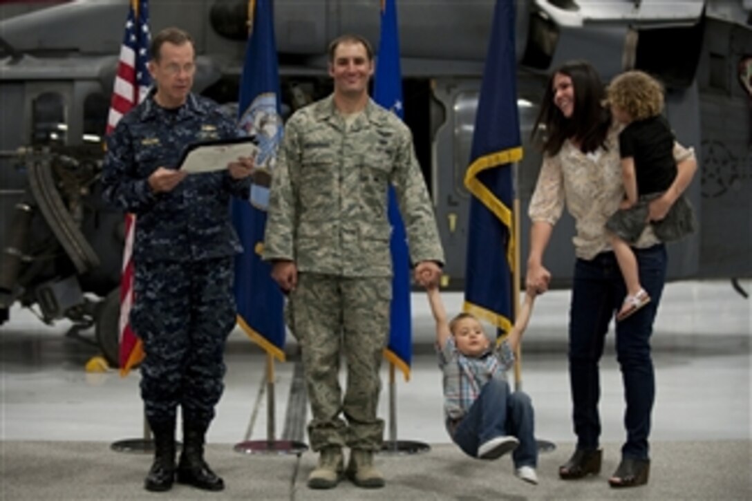 Chairman of the Joint Chiefs of Staff Adm. Mike Mullen, U.S. Navy, reads the citation for the presentation of the Bronze Star to Air Force Staff Sgt. Asher Woodhouse during a visit to Nellis Air Force Base, Nev., on April 13, 2011.  Woodhouse and three fellow pararescuemen assigned to the 58th Rescue Squadron were presented the award for heroism in Afghanistan.  