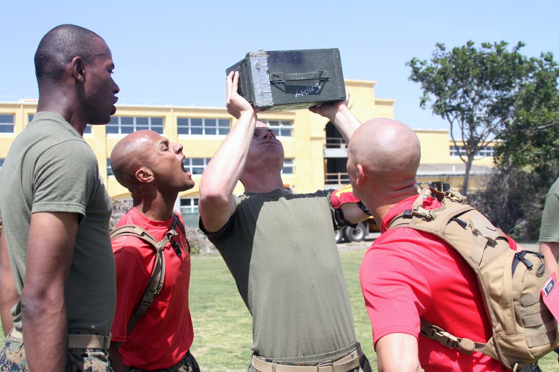 A Company C, 1st Recruit Training Battalion recruit does ammunition can lifts while another recruit counts and drill instructors Sgt. William Caballero and Staff Sgt. Kenneth Oldham motivate him during a Combat Fitness Test April 14.