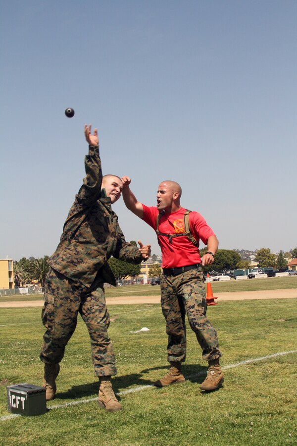Drill Instructor Sgt. Michael Sloan, Company C, 1st Recruit Training Battalion, motivates one of his recruits to throw a simulated grenade during a Combat Fitness Test April 14. If the dummy grenade hits within a certain area, five seconds are subtracted from the overall time.
