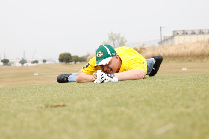 Joseph C. Dilg, a competitor, lines up his putt in the prone postition during the 2011 Boy Scouts of America Golf Tournament at the Torii Pines Golf Course here April 15. Dilg laughed at the many putts it took to sink his ball on the green.